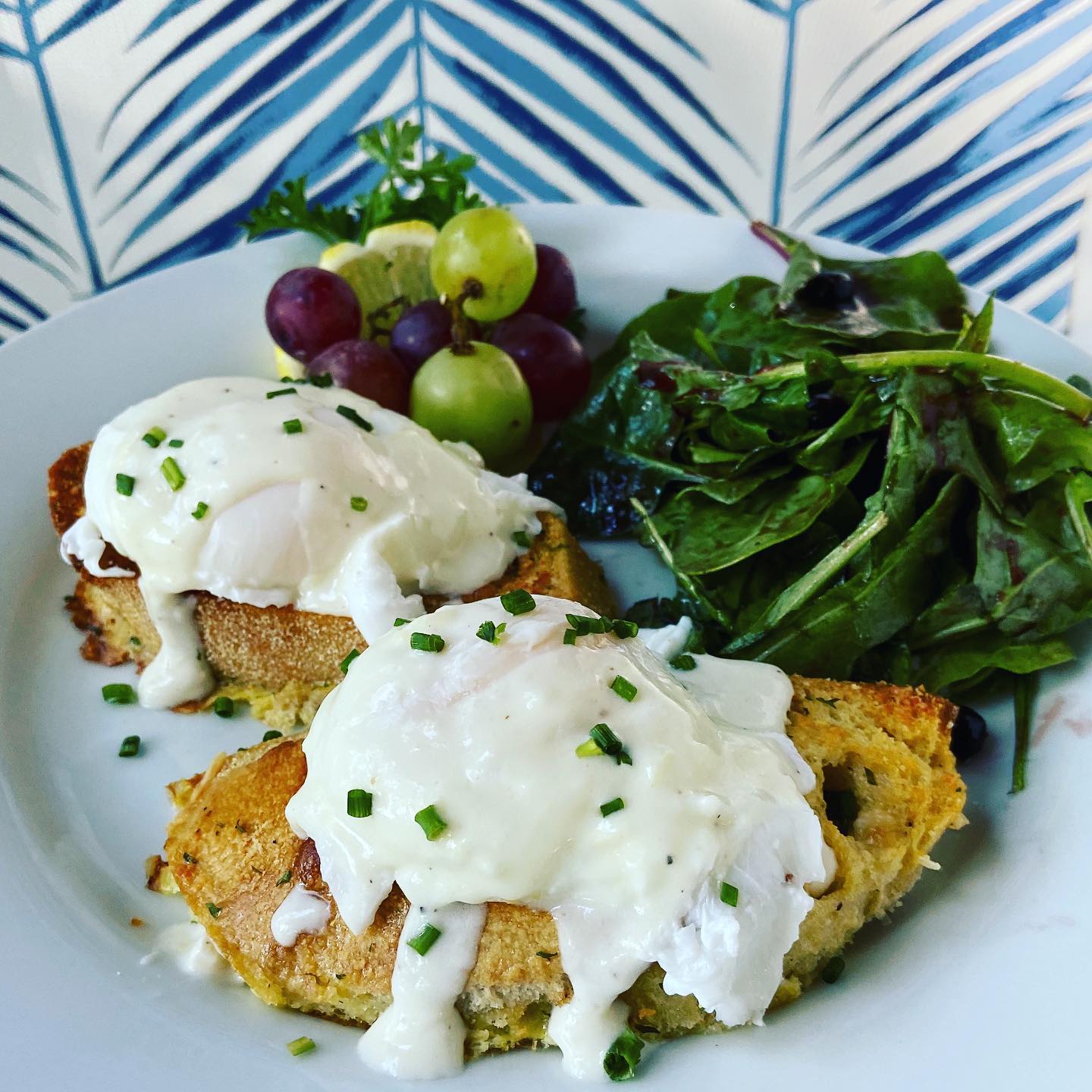 Parmesan “French toast” with poached eggs w Mornay and blueberry dressed greens.